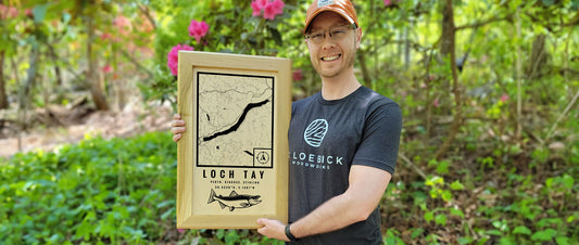 Greg holding a custom wood map of Loc Tay in Scotland