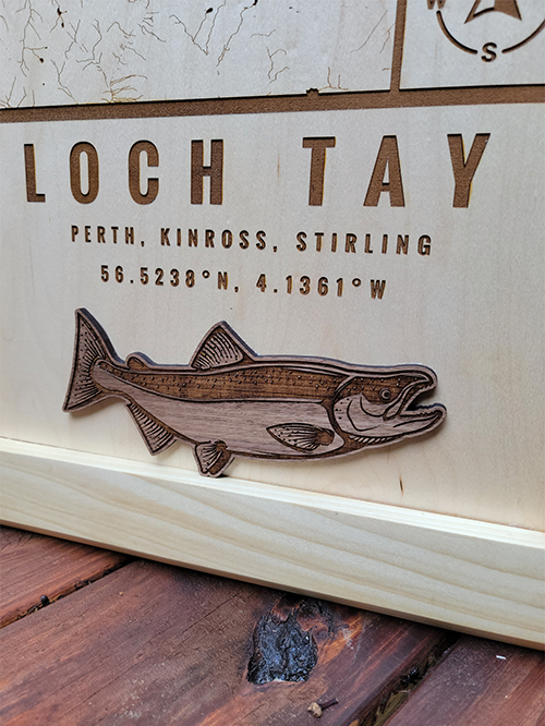 Custom location wood map from G. Loebick Woodworks. Footer graphic of a salmon on a map of Loch Tay Scotland